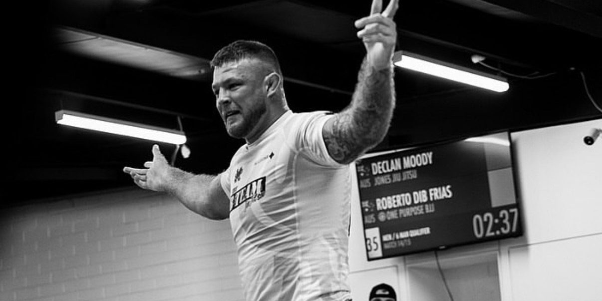 Declan Moody gesturing to the crowd after a match, the scoreboard showing his name