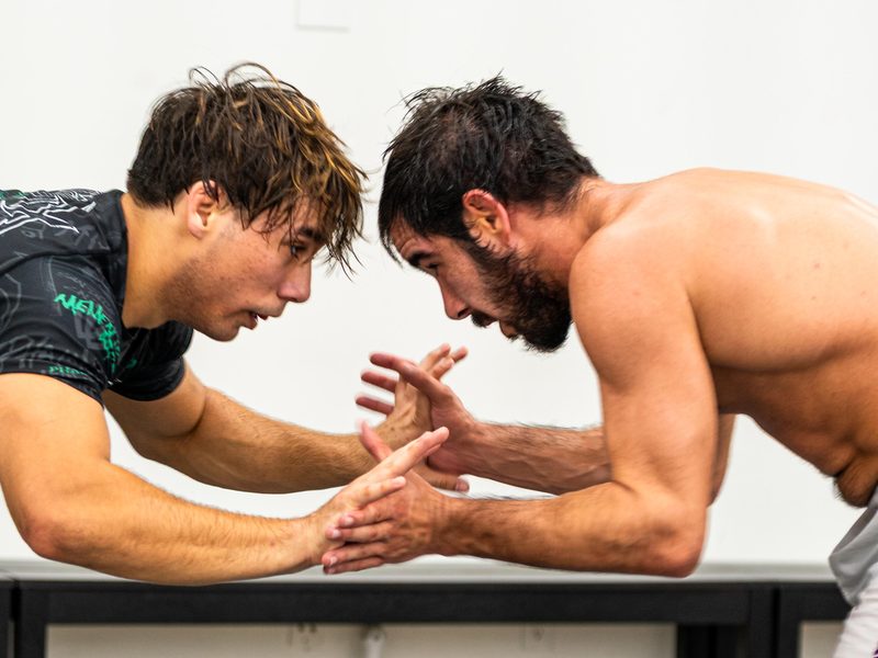Two grapplers hand-fighting for position on the mats