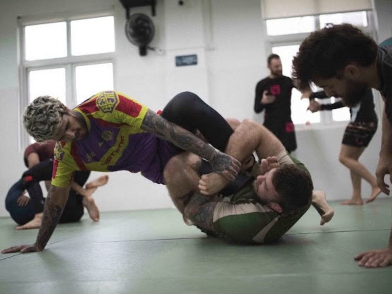 Grapplers rolling on the mats during a training session